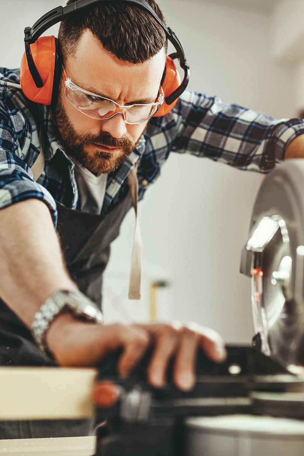 Handwerker beim Sägen (Symbolbild für die Handwerksbranche)